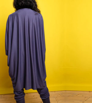 Modell mit dem Rücken zum Betrachter in Cardigan Blaubeere von Stitch by Stitch