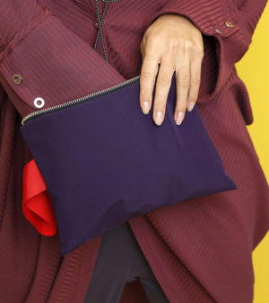 Tragefoto der vielseitig nutzbaren Reißverschluss-Tasche in lila-rot von Stitch by Stitch