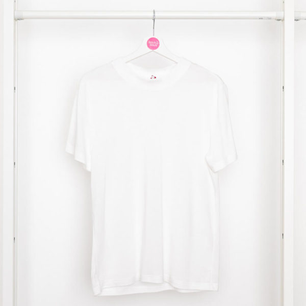 Weißes T-Shirt mit Rundhals-Ausschnitt von Stitch by Stitch auf einem Kleiderbügel hängend